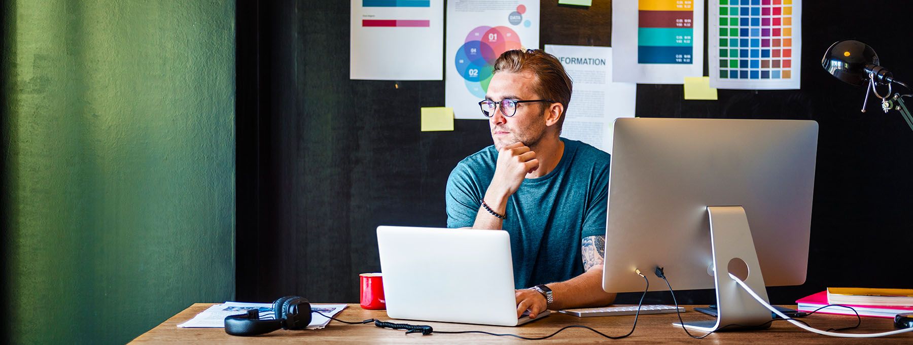 A boy sits at his workplace, relaxed because he has a backup copy of his website.