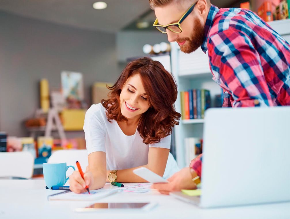 In an office, two colleagues work on their next project with the peace of mind of having a backup copy of their website.