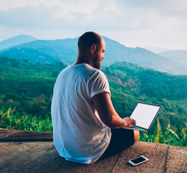 Man with laptop and mobile phone in nature checking his servers