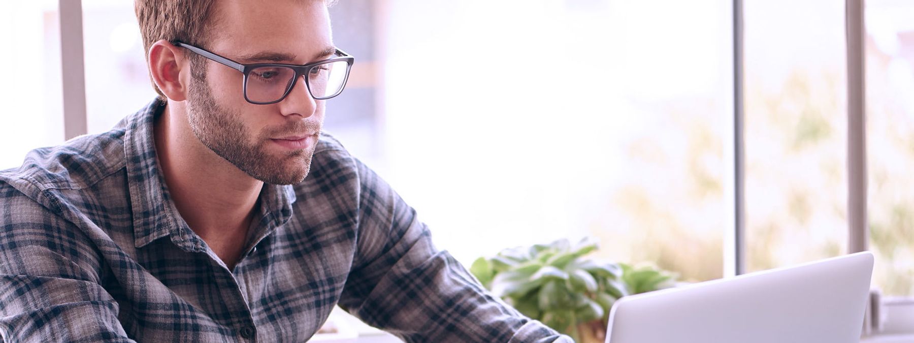 Boy checking on his laptop the benefits of our Hosting reseller plan