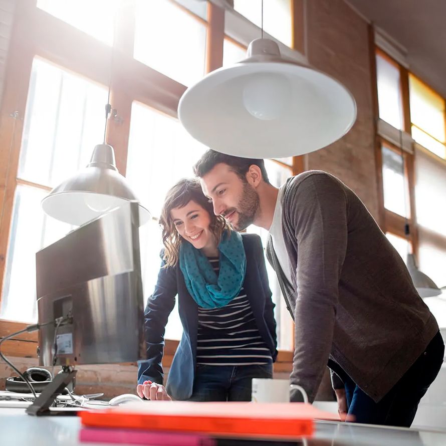 Two colleagues in front of a computer analyzing their SAP HANA solution