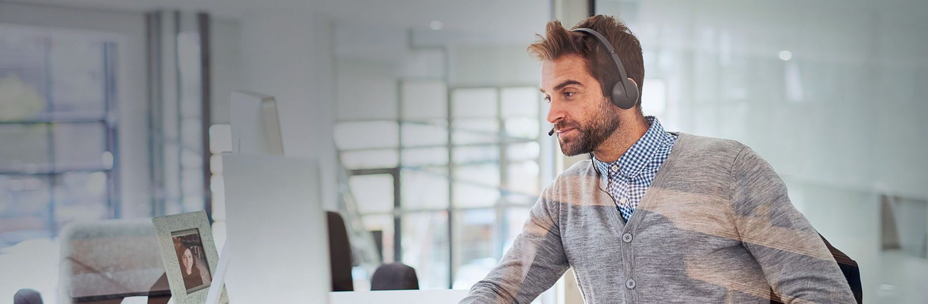 Support agent wearing a headset and in front of a computer listening to your project requirements