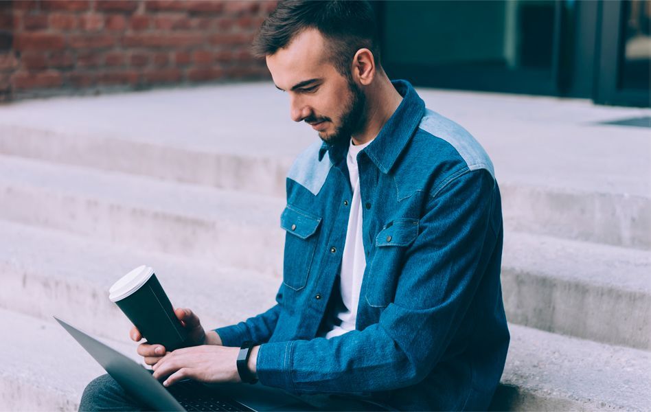 A boy uses his laptop to check how to migrate his email account to Arsys.
