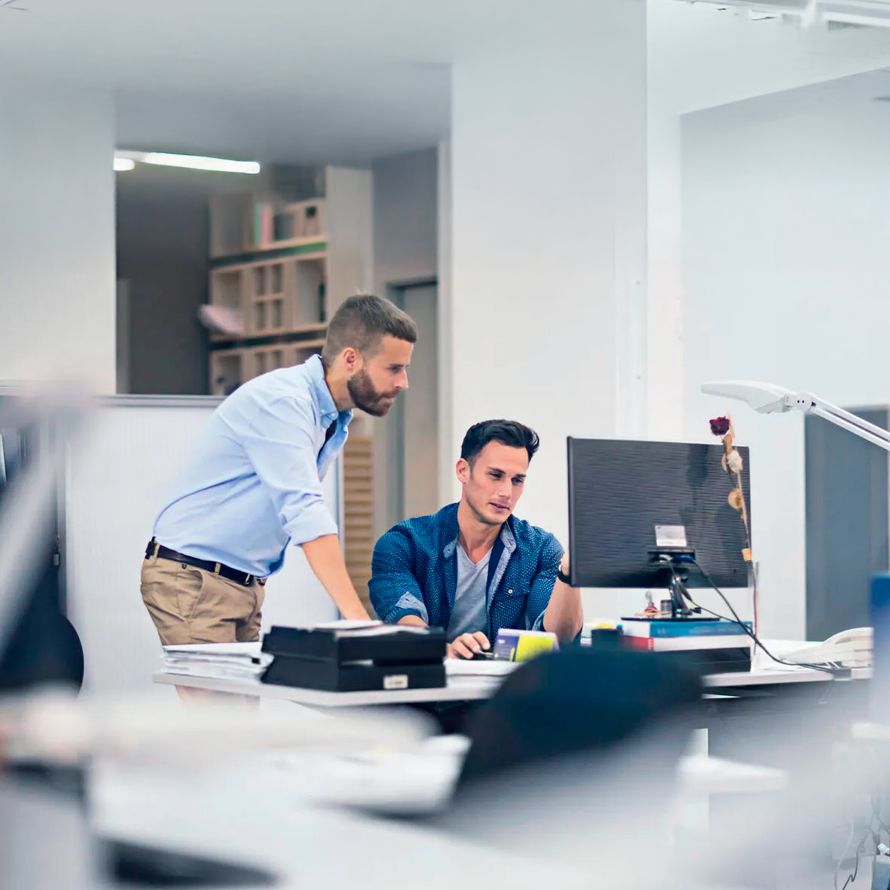 Colleagues in front of a computer checking how their business has grown since becoming partners with Arsys.