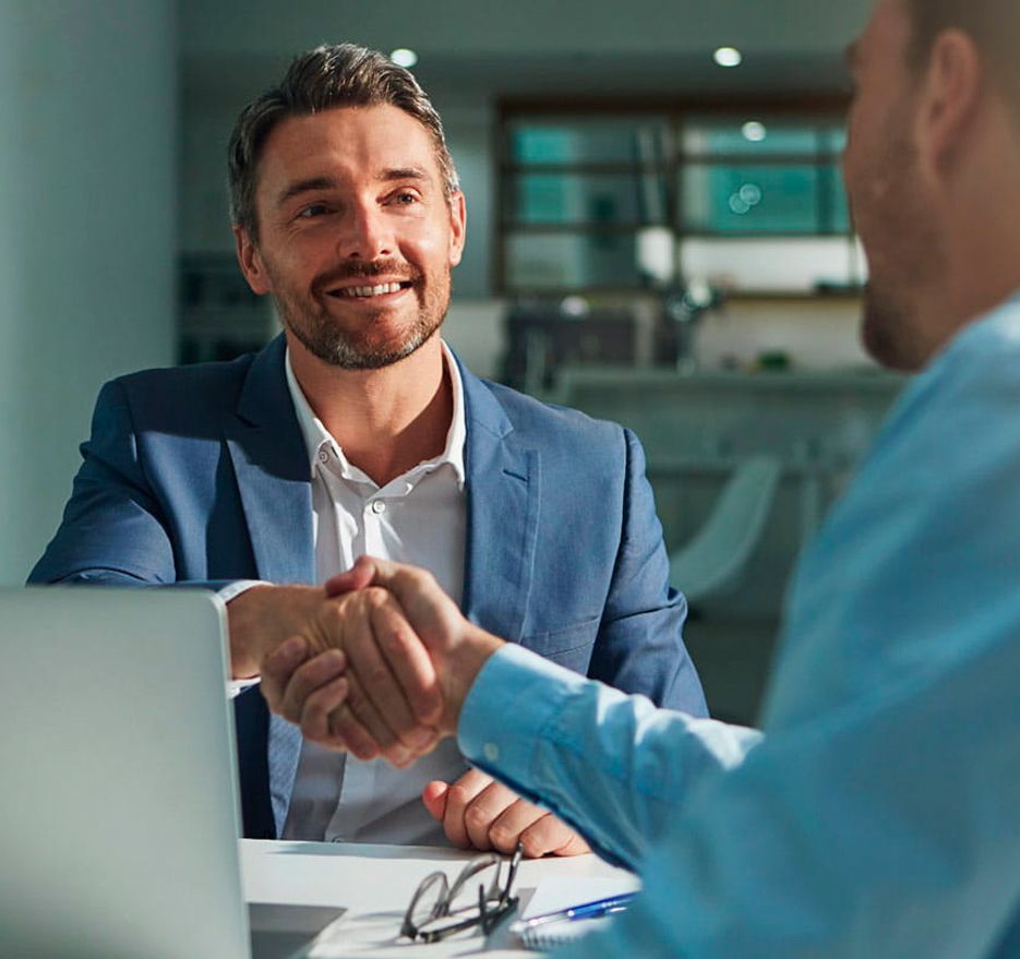 Two men shake hands, sealing a deal.