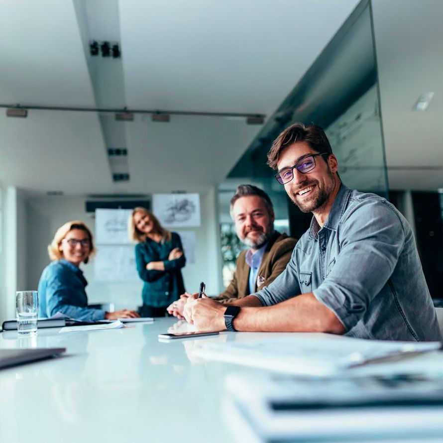 A work meeting where everyone is smiling because they work at Arsys, a company with more than 25 years of experience.