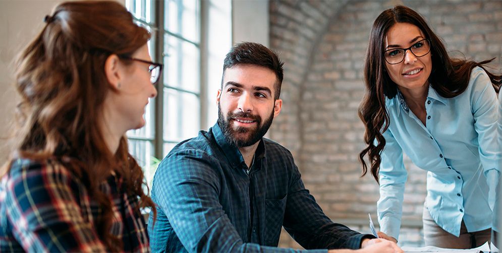 A work meeting where everyone is smiling because they work at Arsys, a company with more than 25 years of experience.
