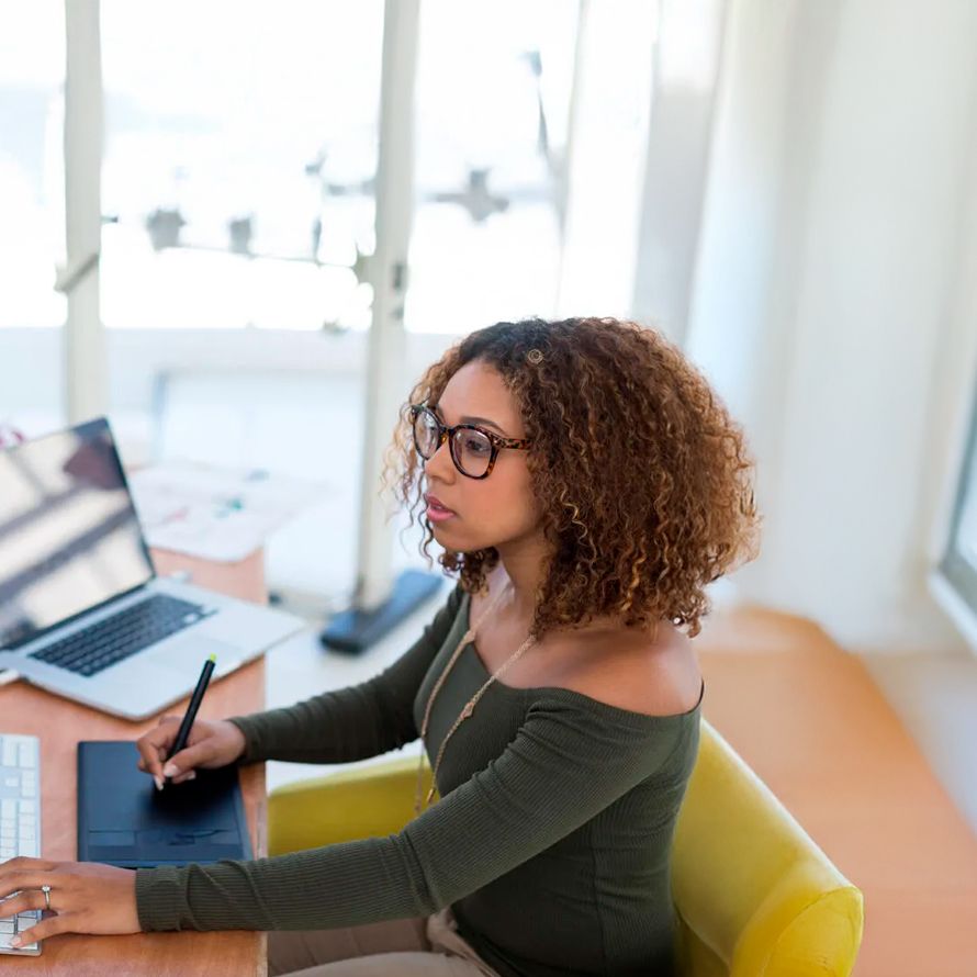 Concentrated girl working on her laptop to create her website