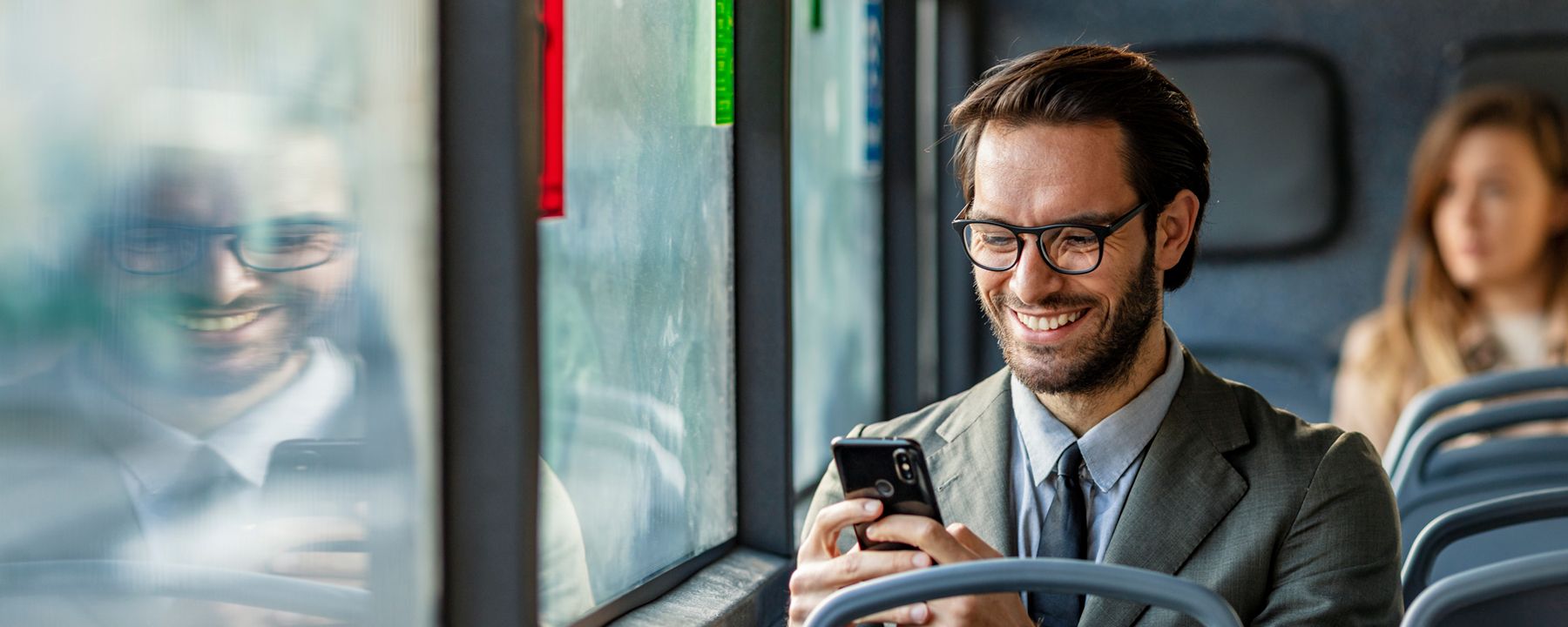 Boy checks his phone on a safe bus because he has our Professional Antivirus service.